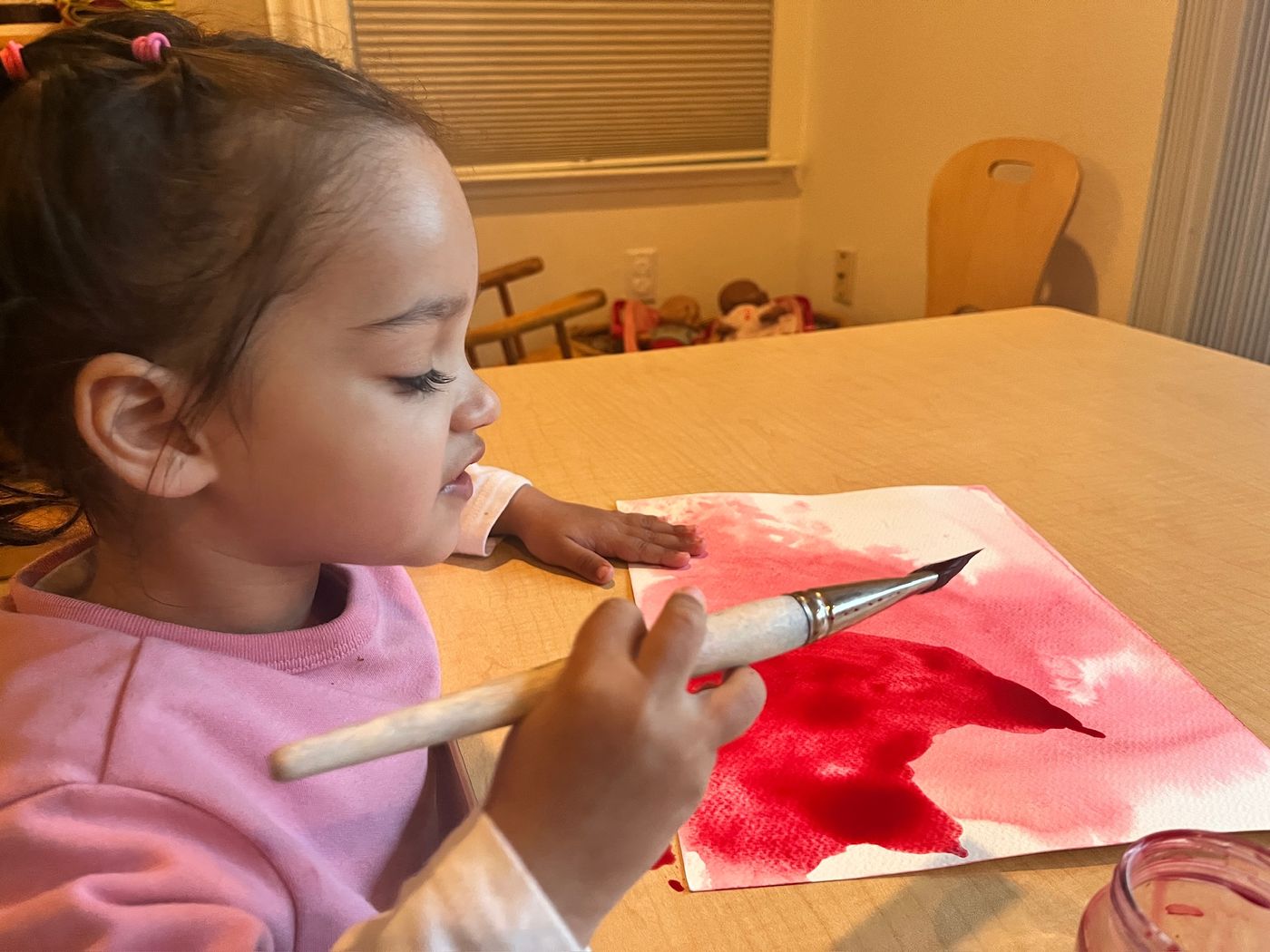 Child admiring her watercolor painting