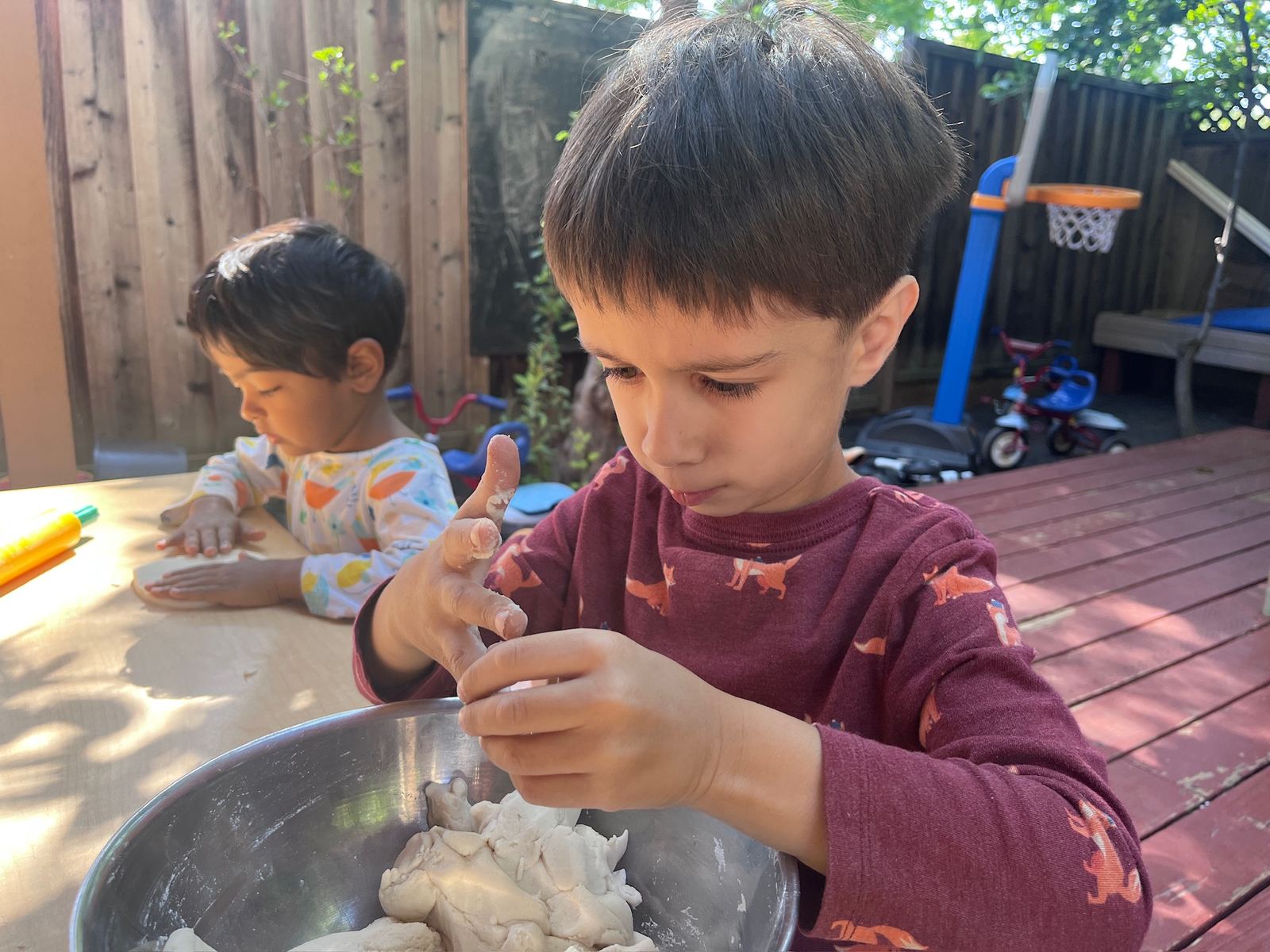 Children working with natural dough at the outdoor craft table