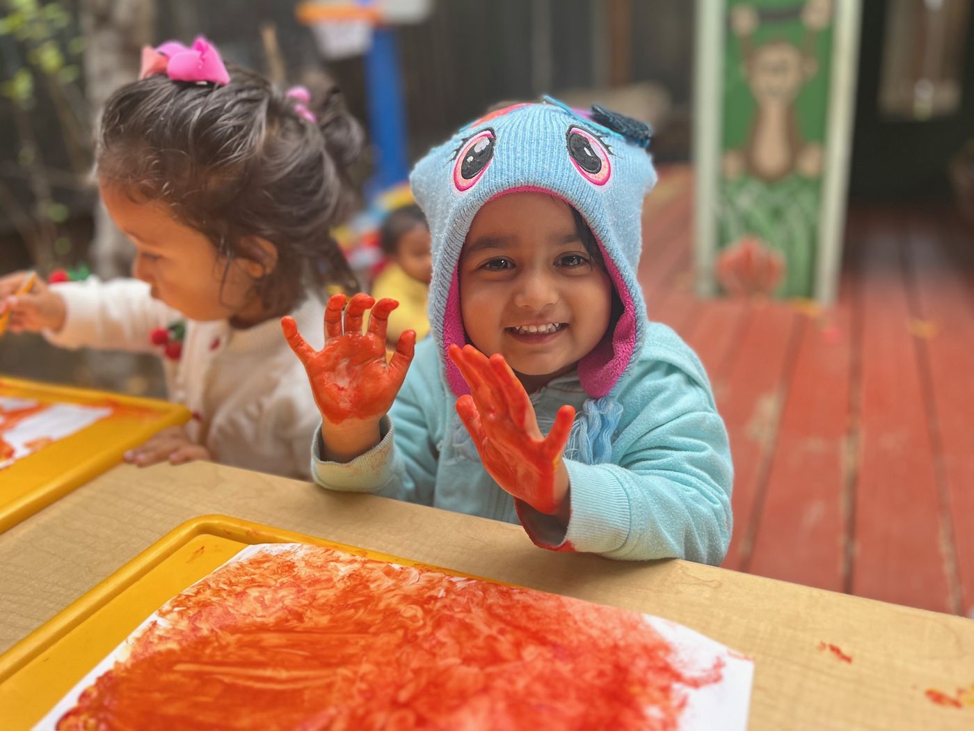 Child with paint-covered hands after a sensory art project