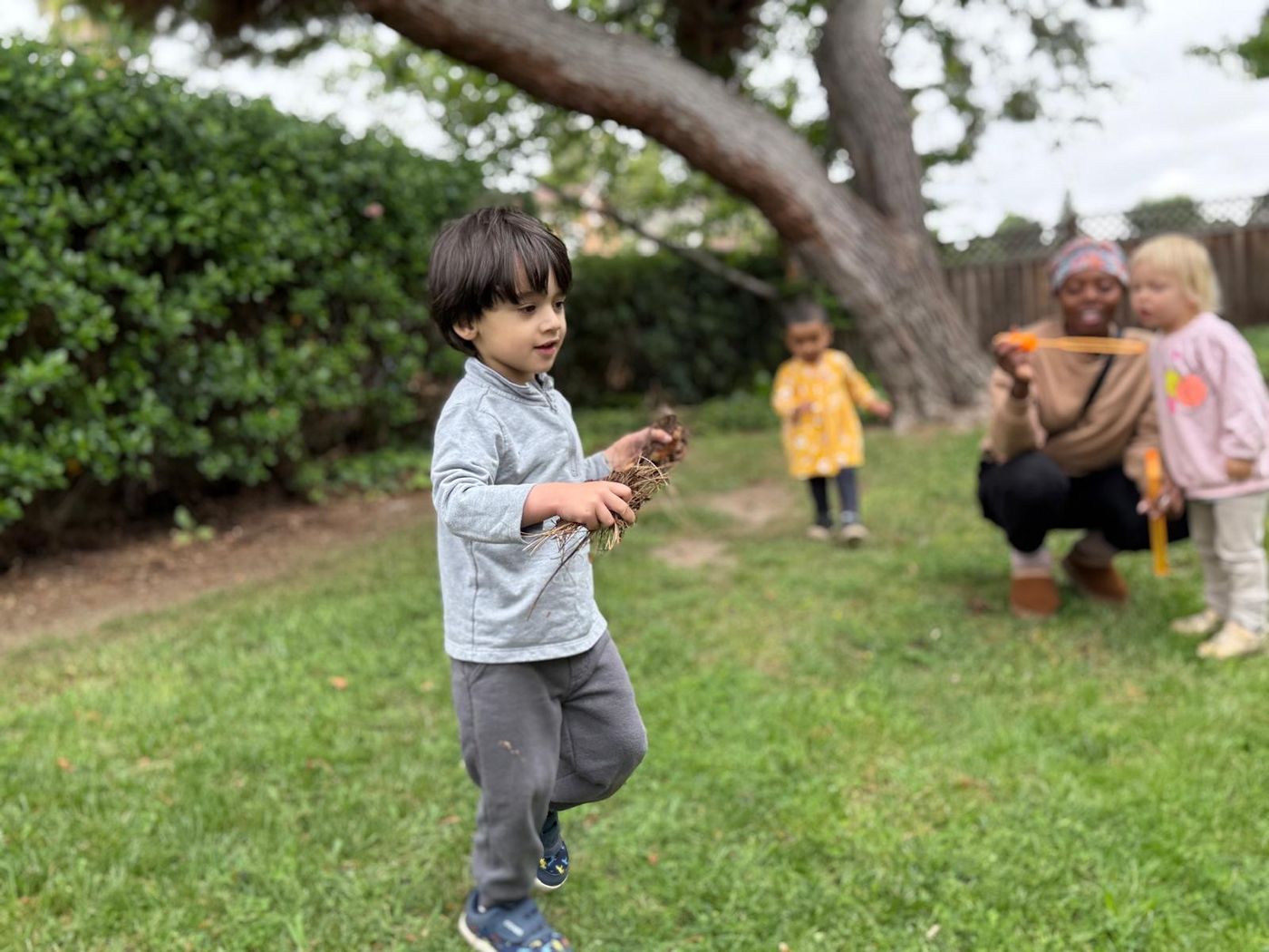 Child exploring nature outdoors with sticks and leaves