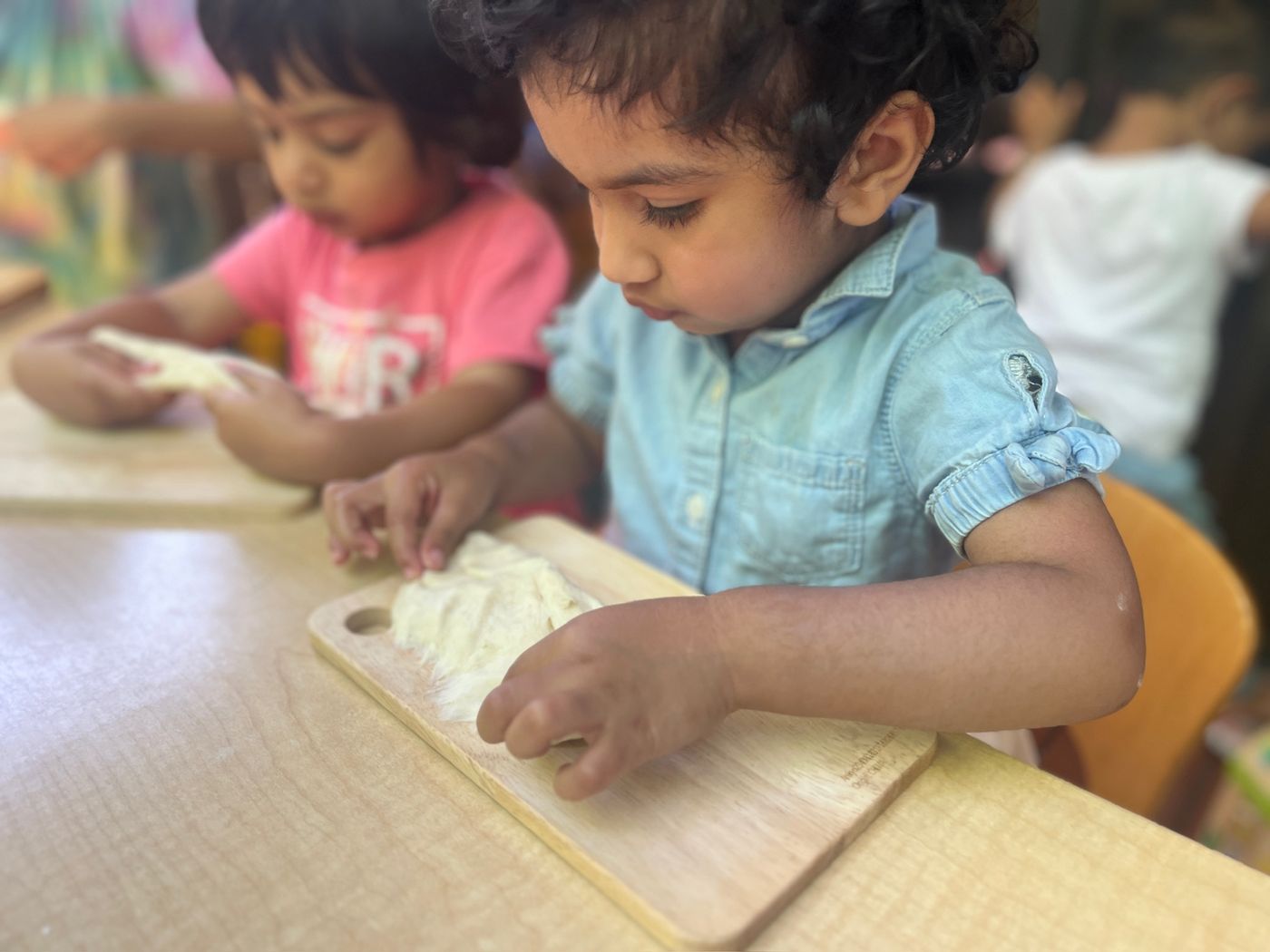 Children shaping bread dough with their hands