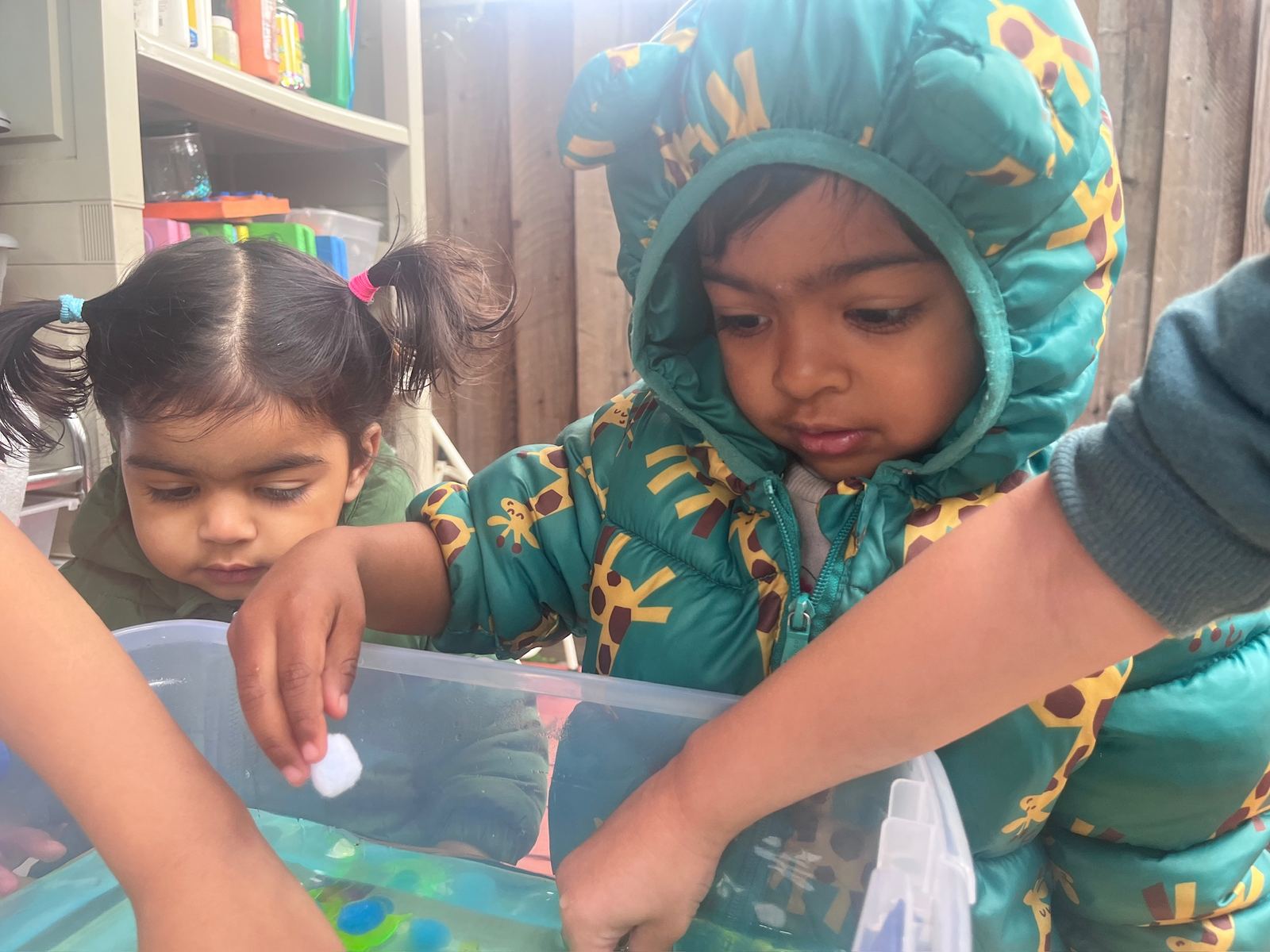 Toddlers exploring a water sensory bin